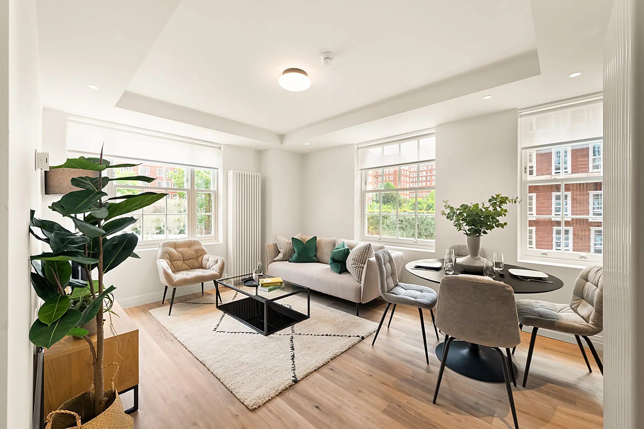 Bright living room with dining table and sofa and large windows in a Short Term Furnished Rentals in London for Insurance Claims